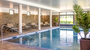 An indoor swimming pool with lounge chairs and a potted plant. - Château des Vigiers (Monestier)