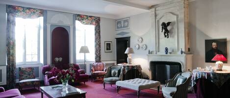 A traditional room with a fireplace, floral curtains, and classic furniture.