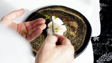 A person holding a spoon over a bowl with a dark, speckled interior.