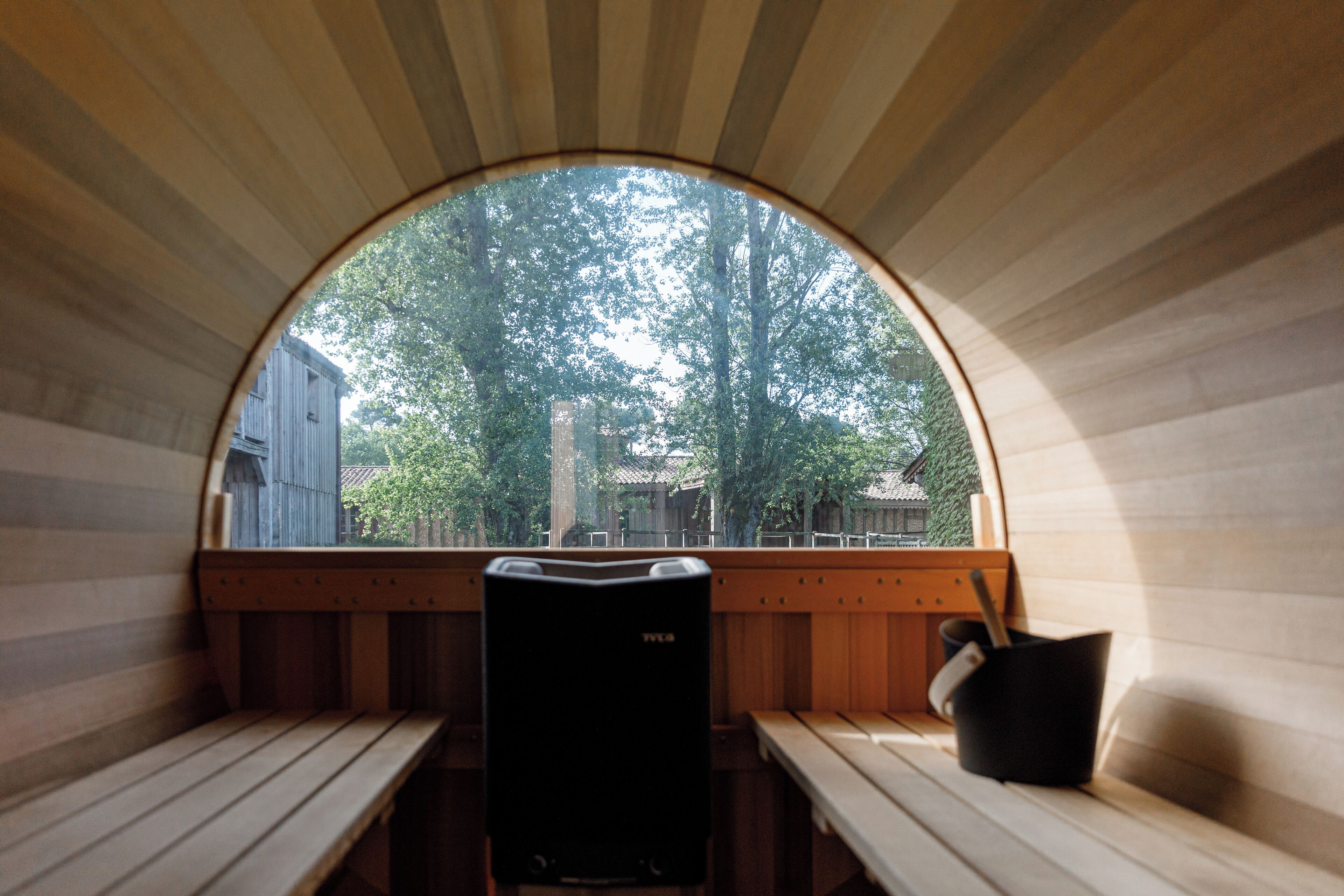 Ein Saunaraum mit Holzbänken und einem großen Bogenfenster.
