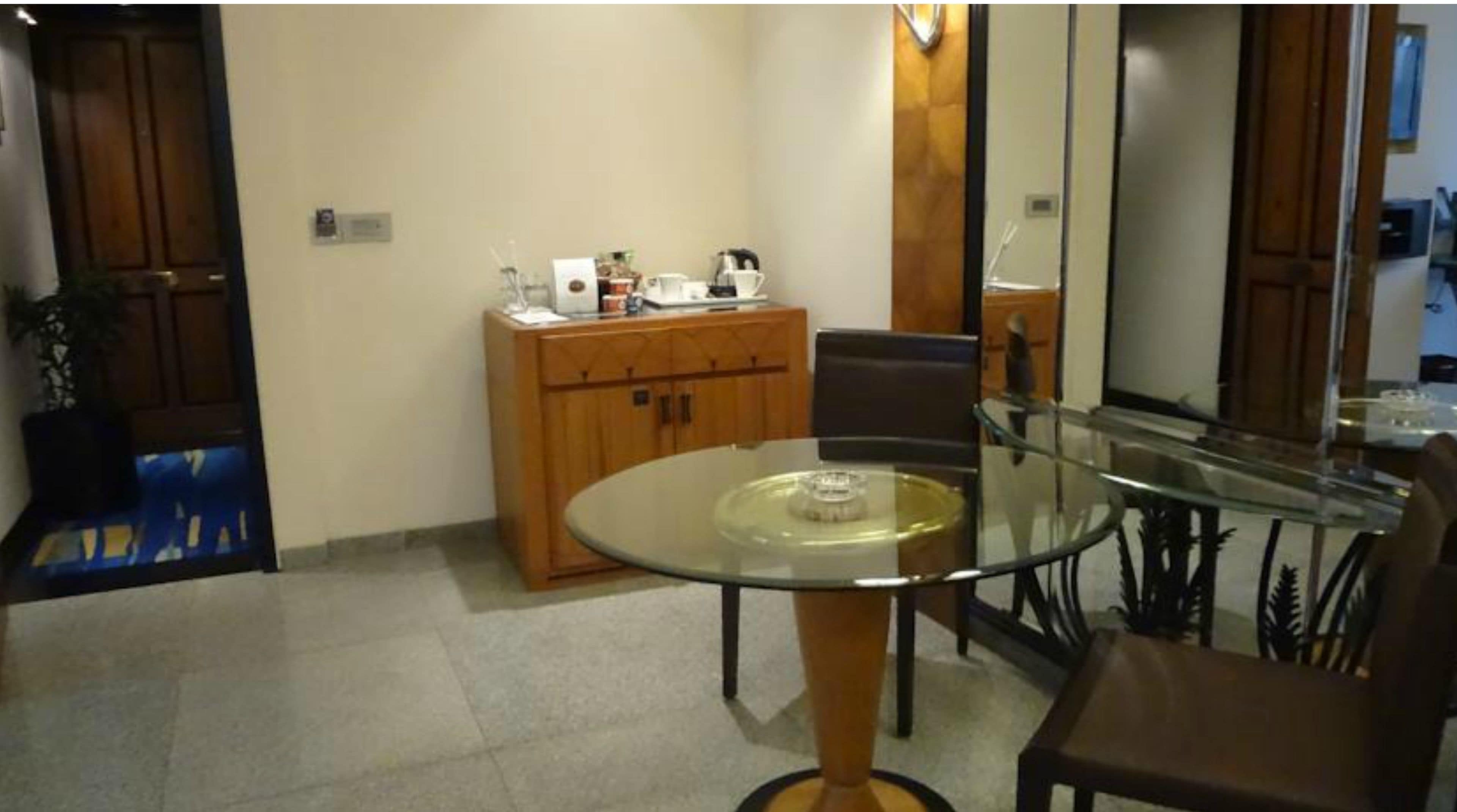 A dining area with a glass table, wooden cabinets, and a chair.