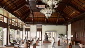 A spacious lobby with high ceilings, large windows, and elegant furniture. - Kamandalu Ubud (Ubud)