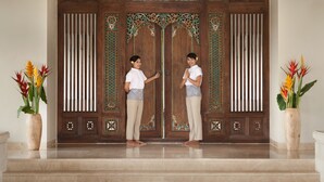 A wooden door with intricate carvings and a mirror above it.