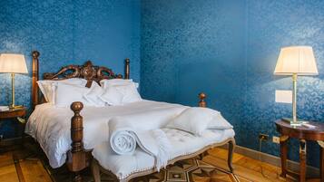 A neatly made bed with white linens, a wooden headboard, and a geometric patterned floor.