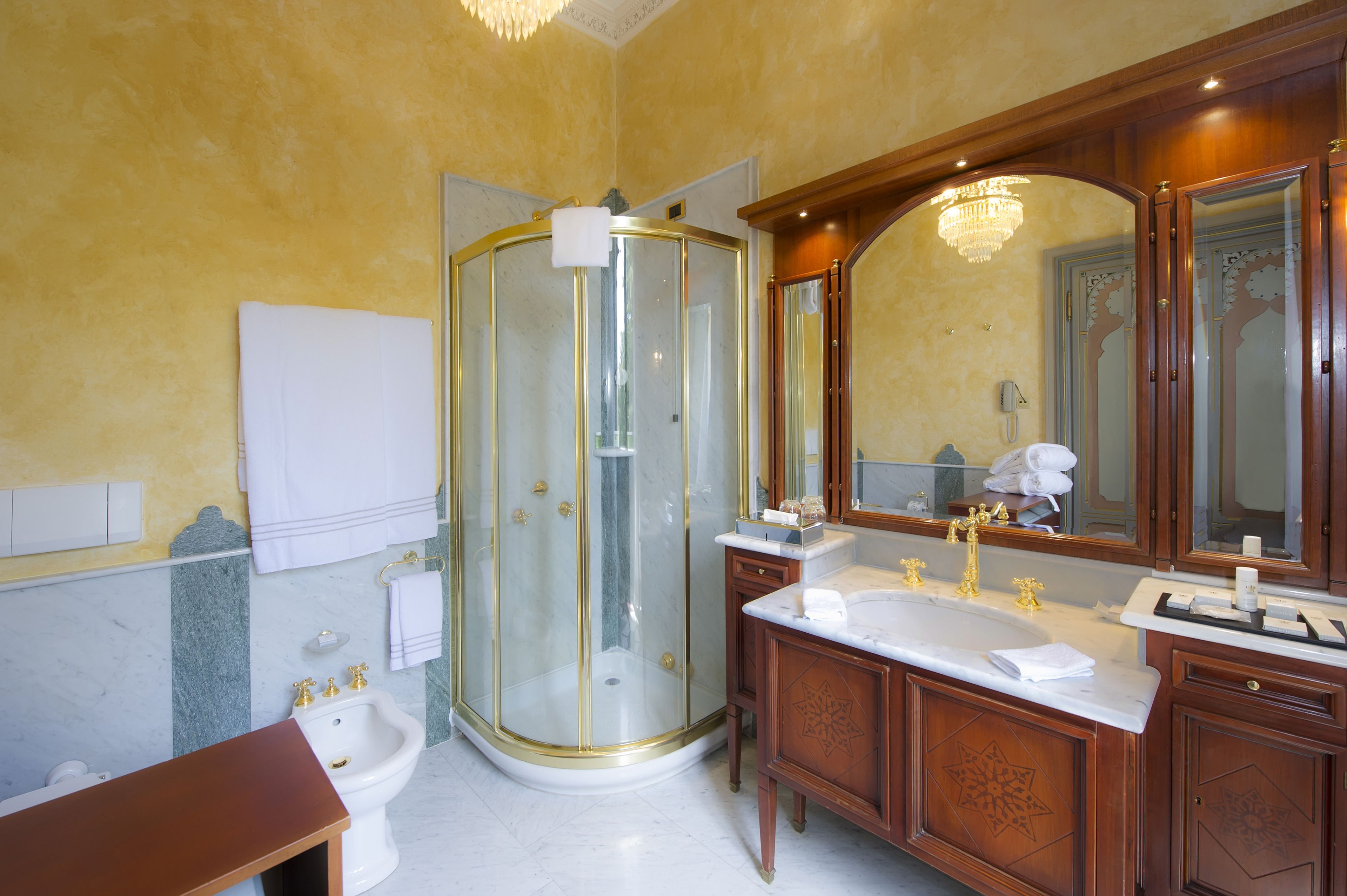 A bathroom with a glass-enclosed shower, a double sink vanity, and a large mirror.