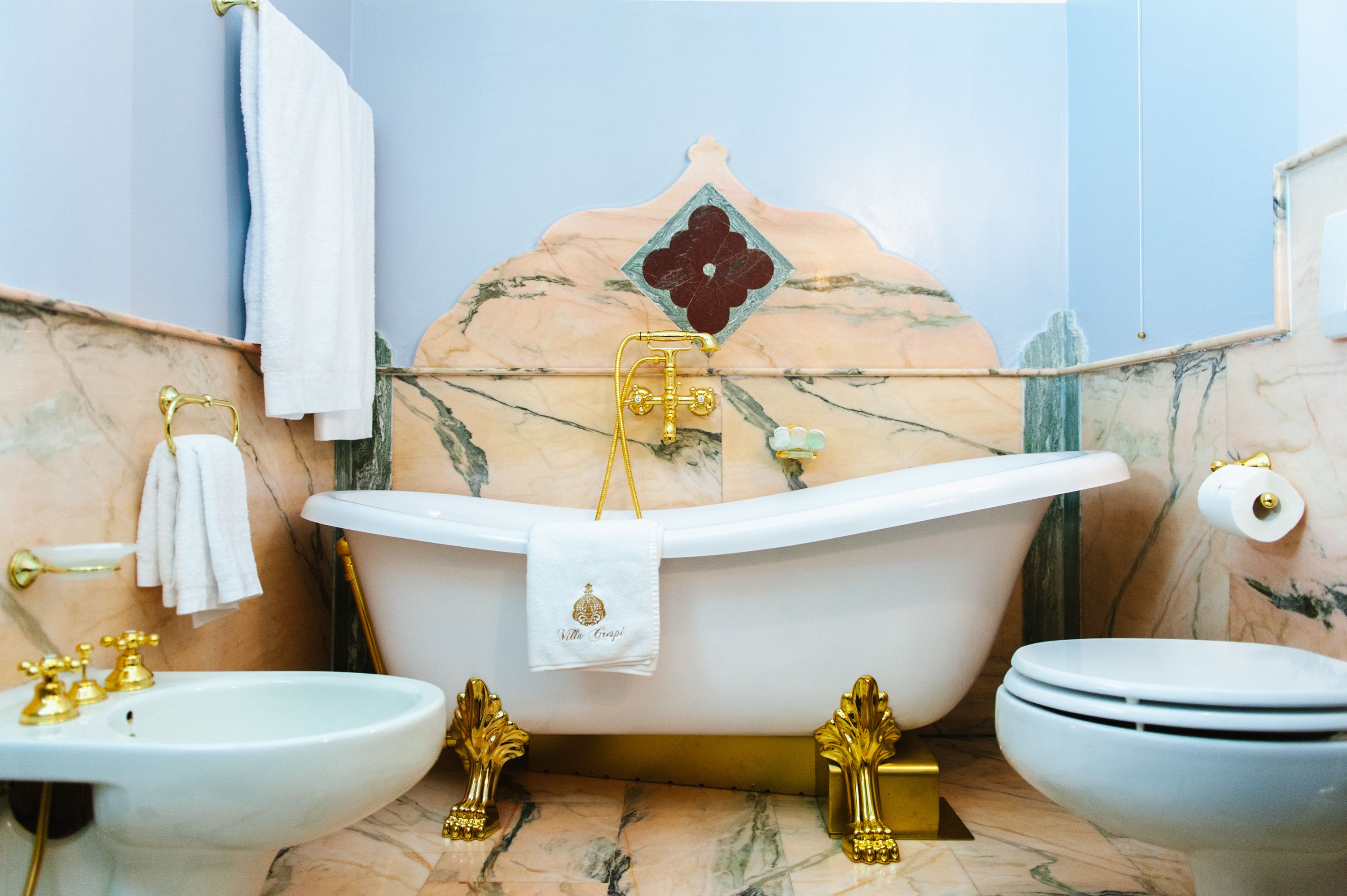 Un baño con bañera independiente, dos lavamanos y un inodoro.