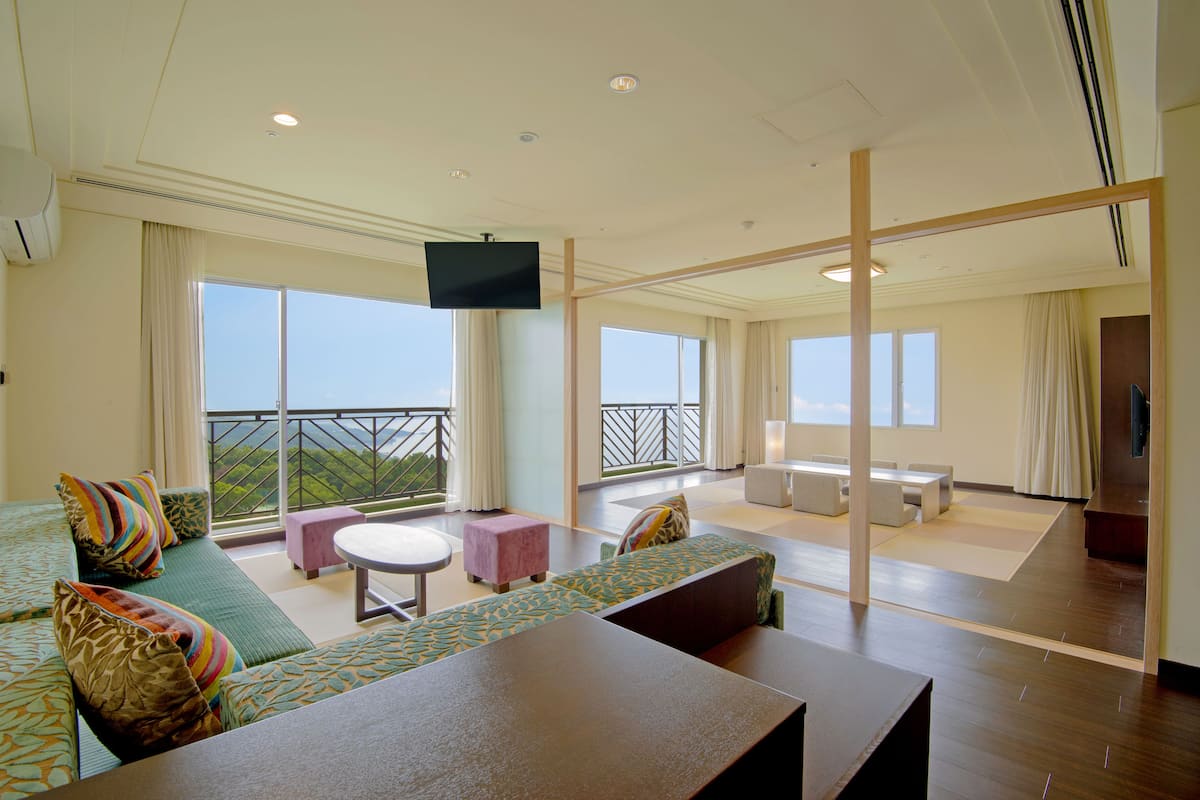 A spacious balcony with a sofa, a small table, and a TV.