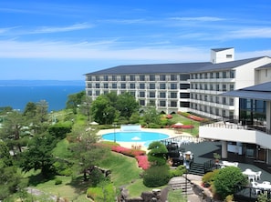 A hotel with a pool, lush greenery, and a view of the sea. - Resort Olivean Shodoshima (Tonosho)
