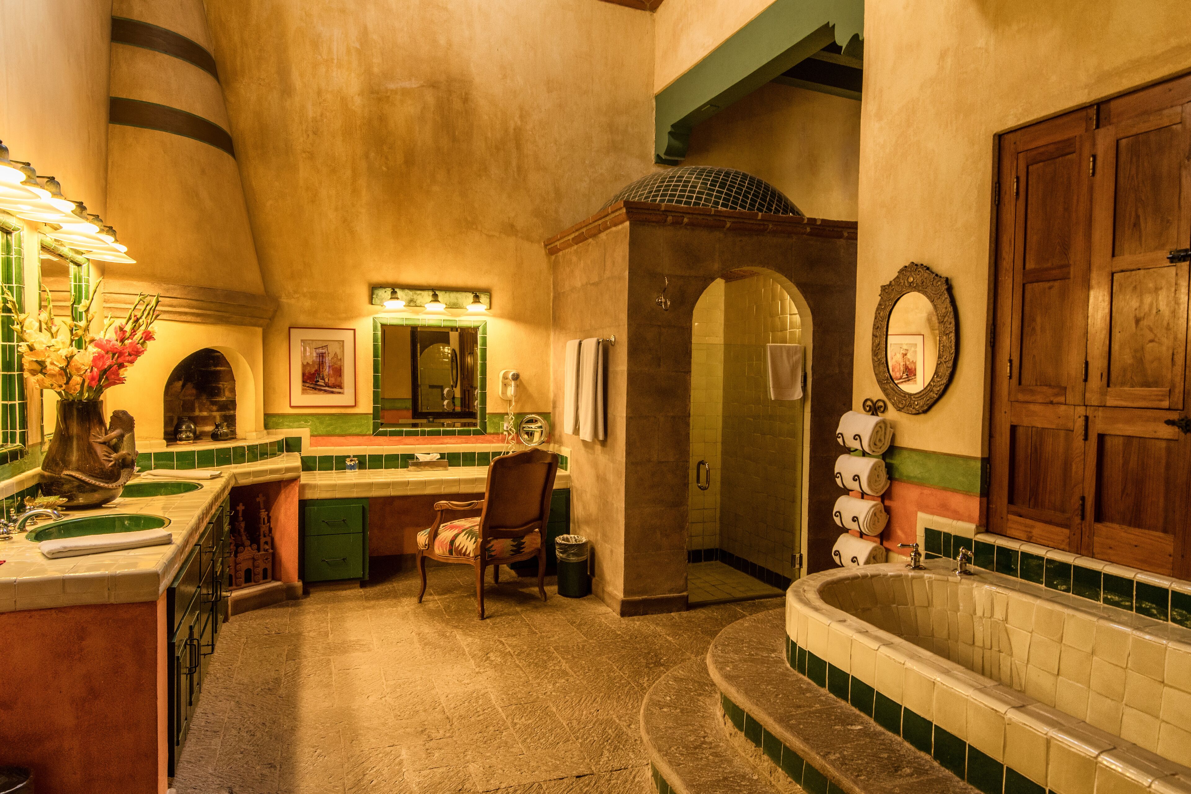 A bathroom with a bathtub, a sink, a chair, and a mirror.
