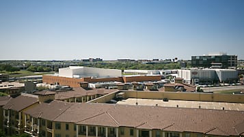 A multi-story building with a flat roof and a parking lot in front.