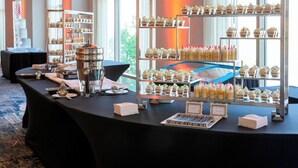Una mesa de buffet con distintos alimentos y una vitrina con postres.