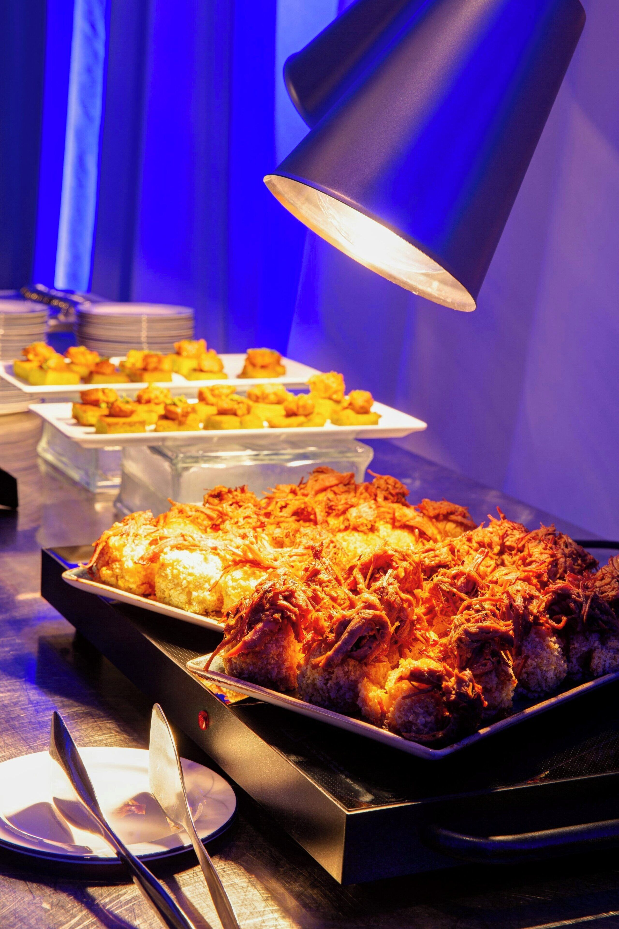 Une table de buffet proposant divers plats, mise en valeur par un projecteur.