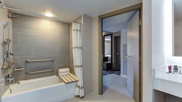 Un baño moderno con bañera, ducha y barras de apoyo.