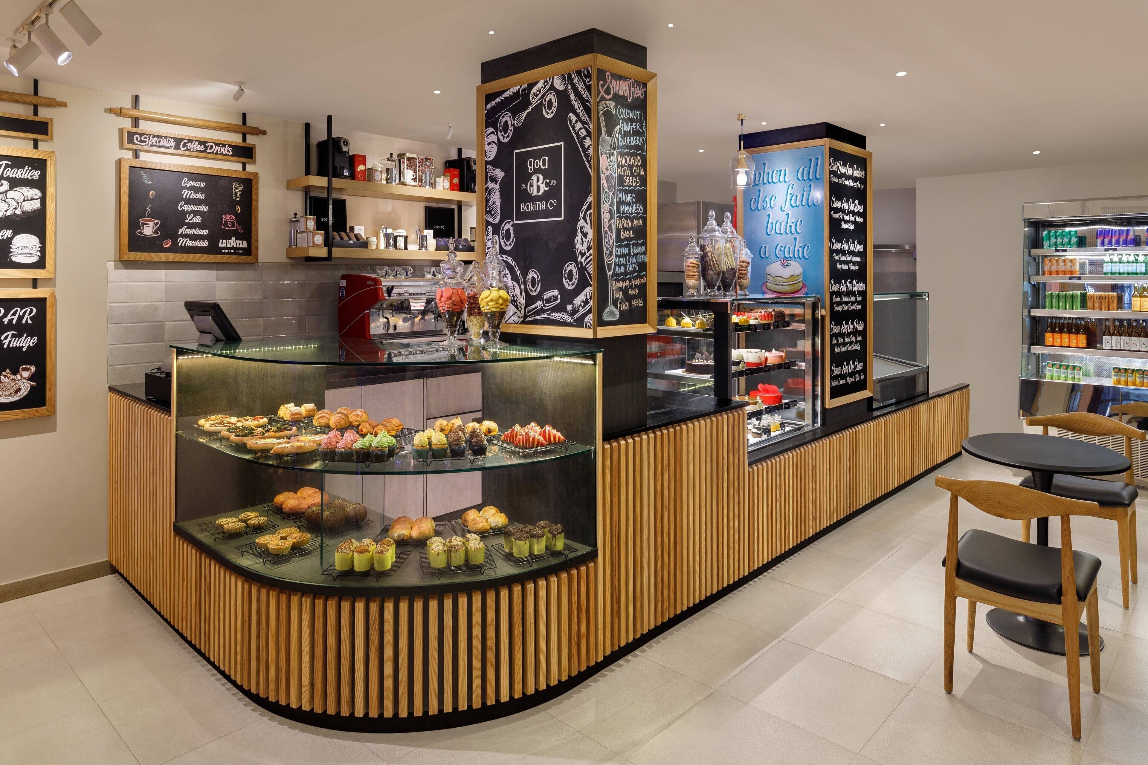 Mostrador de panadería con diversos pasteles y postres a la vista.