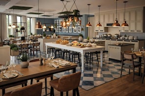 Una cocina moderna con una isla central, iluminación colgante y piso a cuadros.