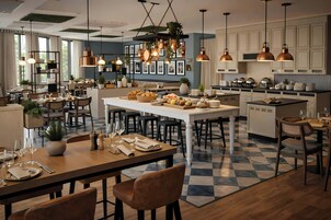Una cocina moderna con una isla central, iluminación colgante y piso a cuadros.
