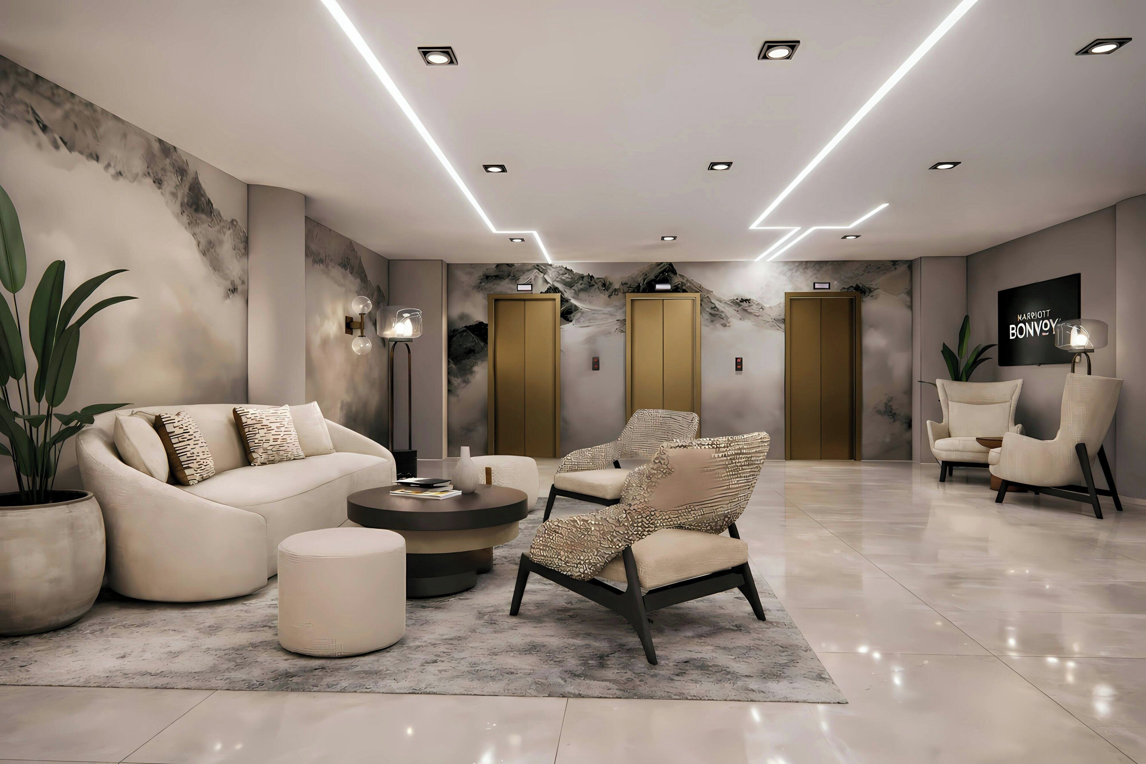 Eine moderne Hotelhalle mit einer Sofagarnitur, Sesseln, einem Couchtisch und einer großen Kübelpflanze.