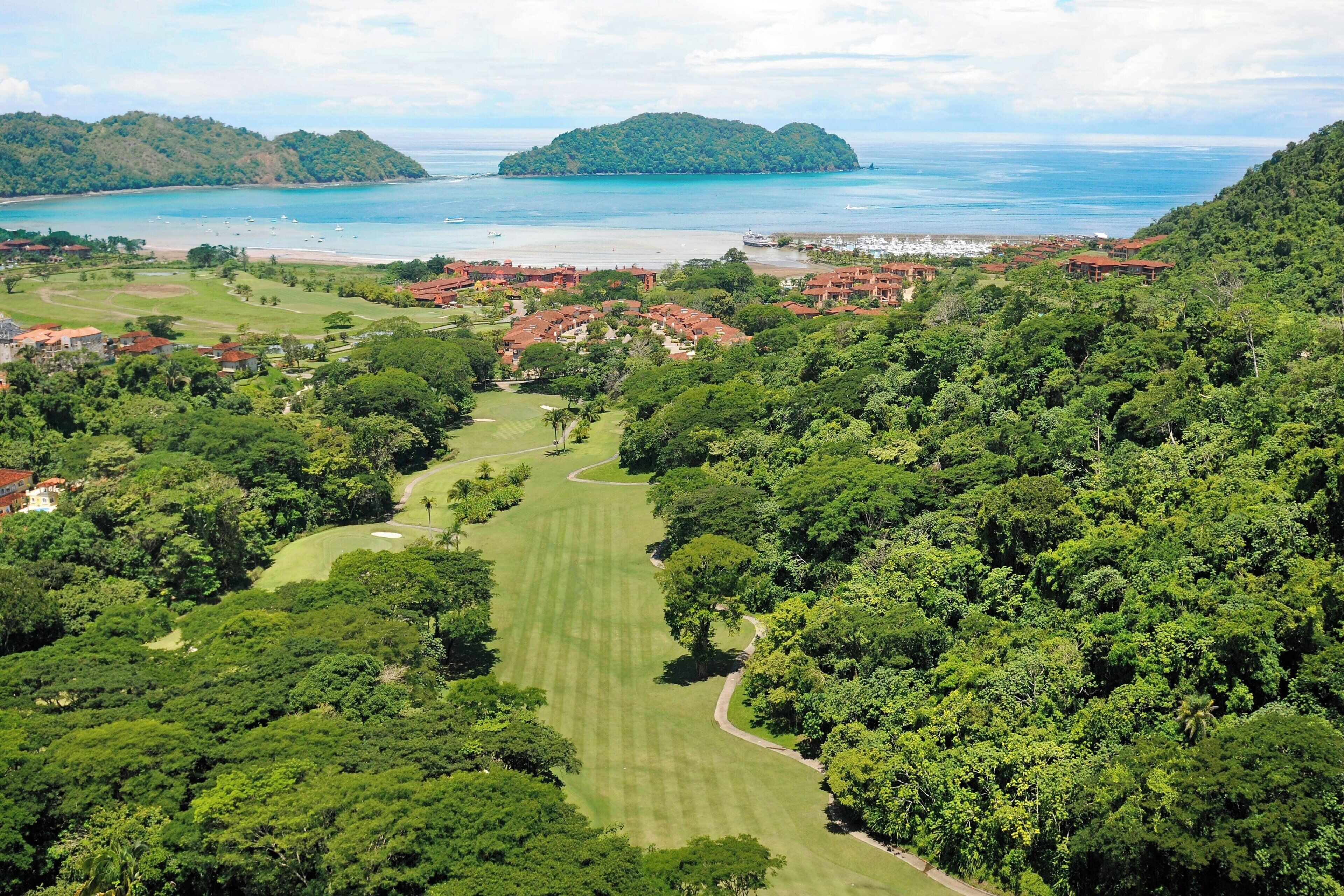 Camp de golf amb vista a l'oceà i una petita illa.