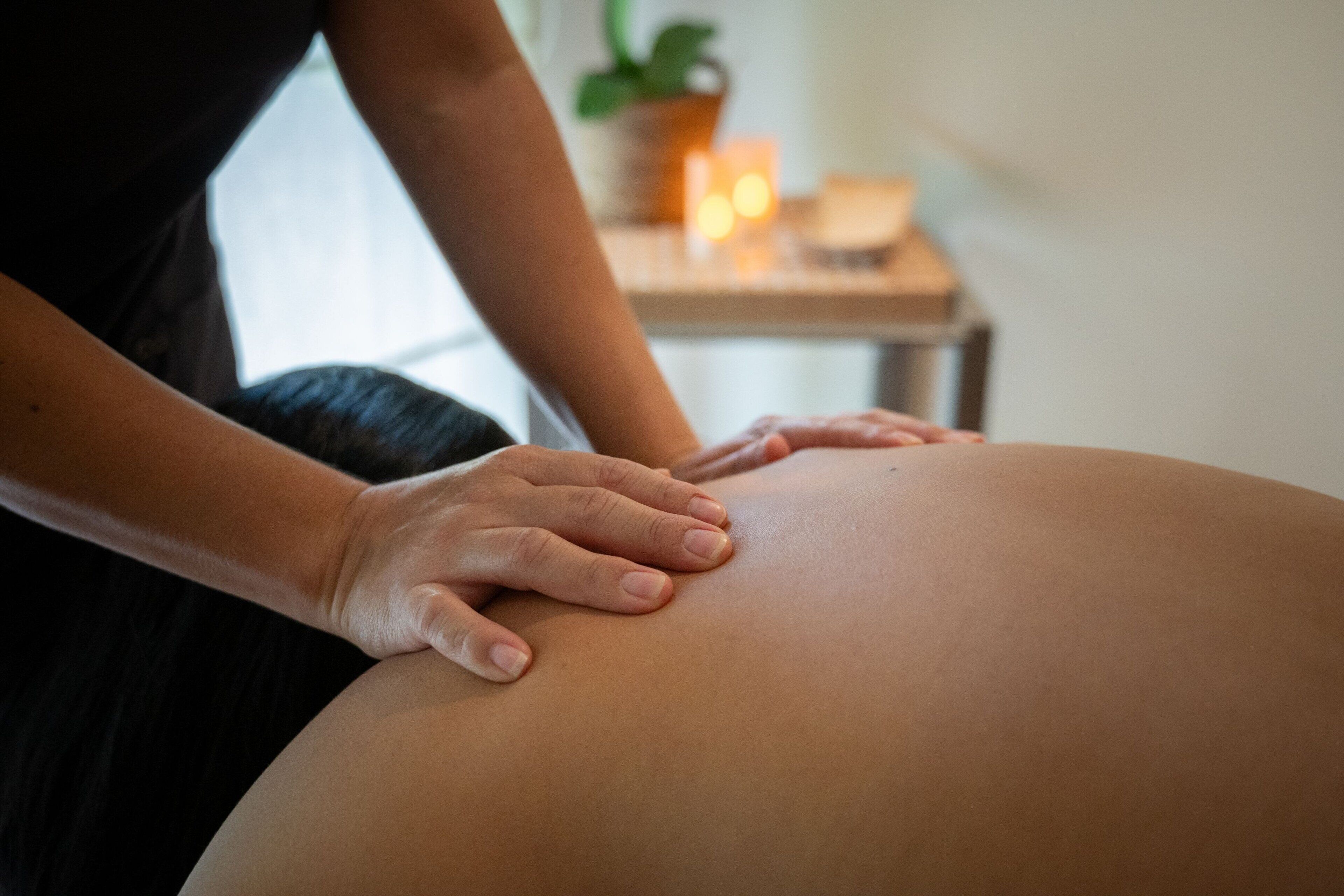 A massage therapist's hands on a client's back.