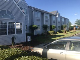 Edificio residencial con un cartel que indica registro de huéspedes y estacionamiento por 10 minutos.