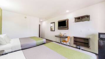 A hotel room with two beds, a desk, a chair, a TV, and a small table.