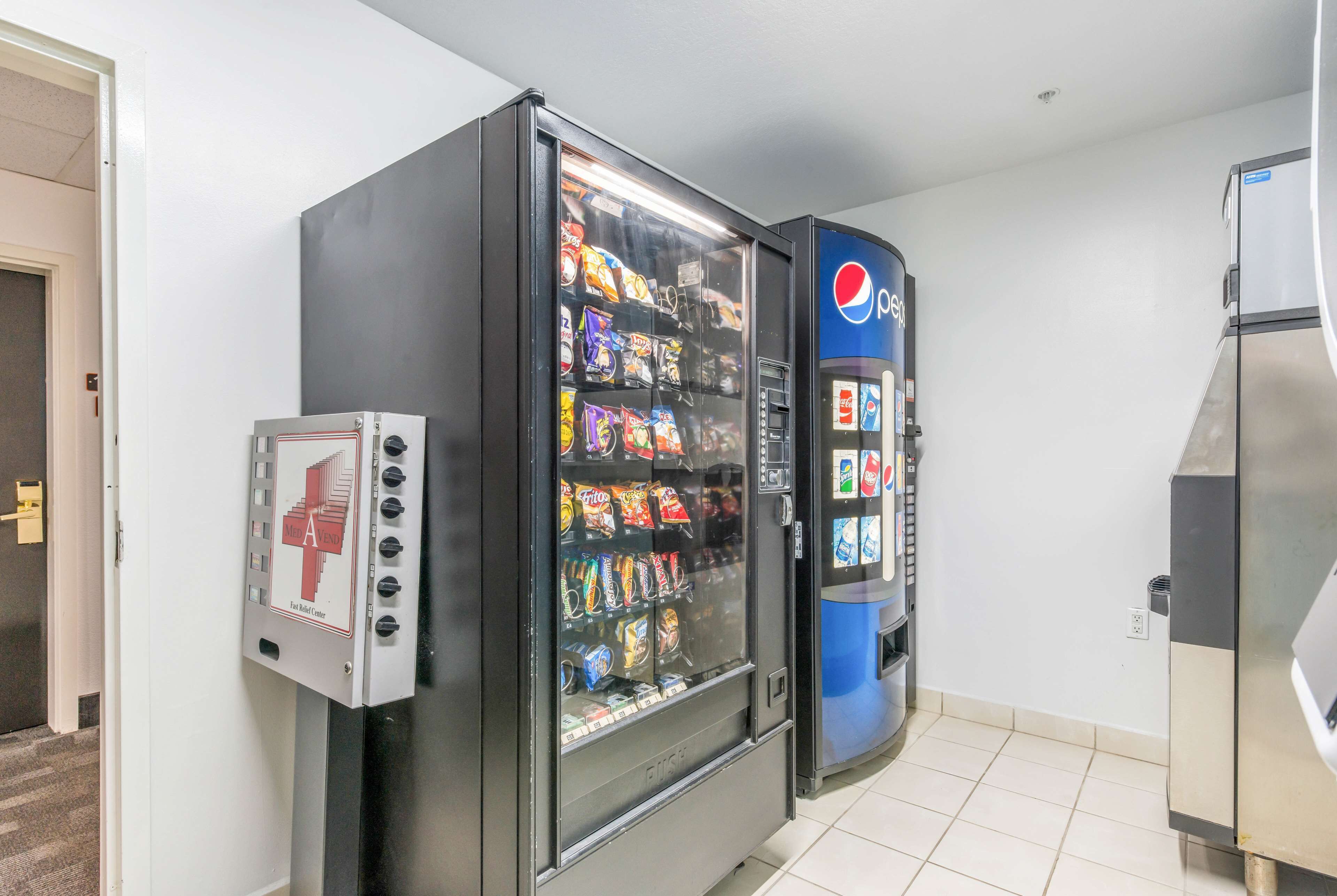 A vending machine with snacks and a Pepsi dispenser in a hotel room.