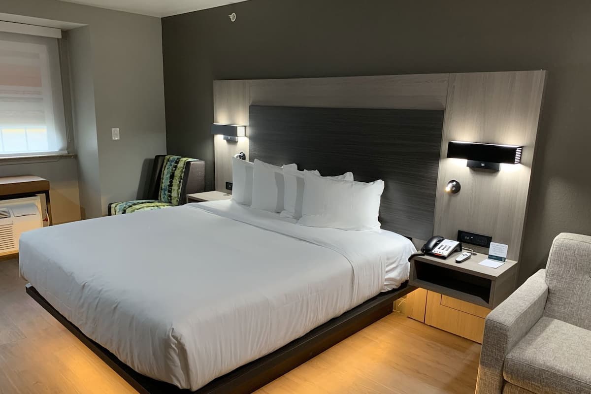 Une chambre d’hôtel moderne avec un grand lit, des tables de chevet, un bureau et une chaise.