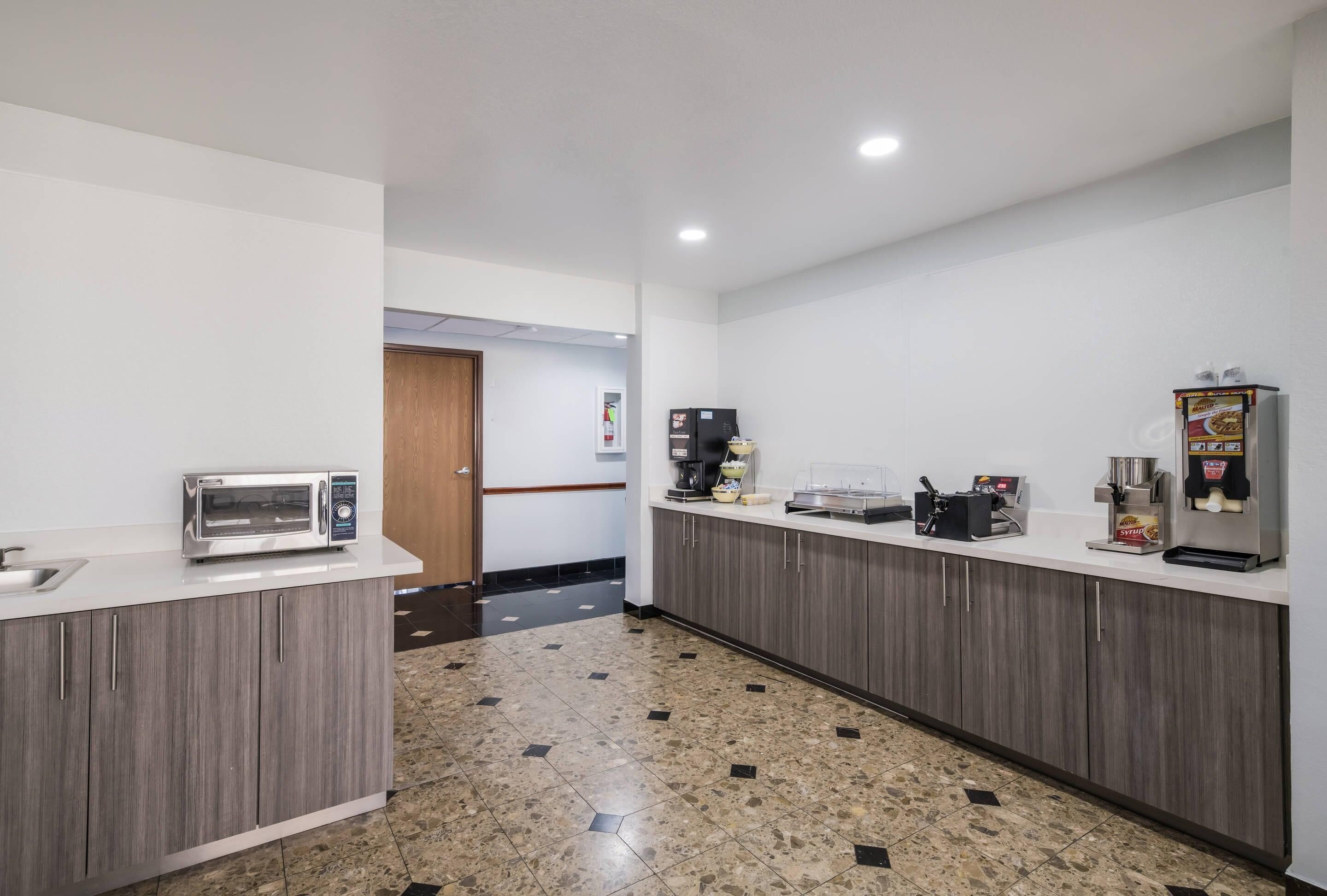 Eine moderne Küche mit Mikrowelle, Kaffeemaschine und Kühlschrank.