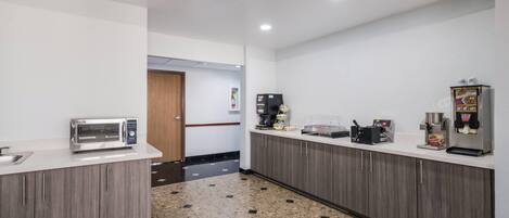 Eine moderne Küche mit Mikrowelle, Kaffeemaschine und Kühlschrank.