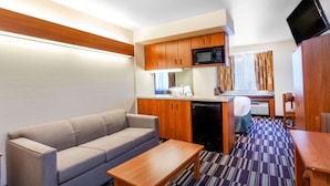 A compact kitchenette with a microwave, sink, and a small dining area. - Microtel Inn & Suites by Wyndham Gulf Shores (Gulf Shores)