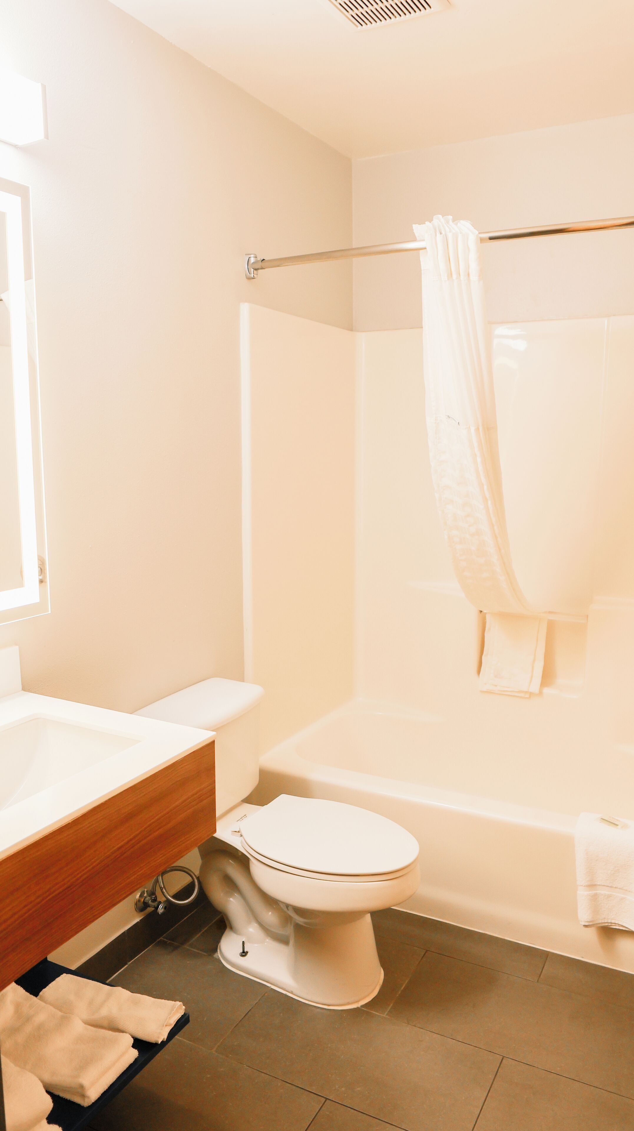 A bathroom with a white toilet, a bathtub, and a shower curtain.