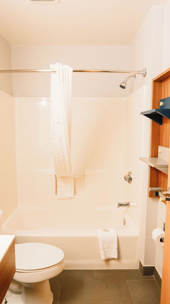 A bathroom with a bathtub, toilet, and shower.