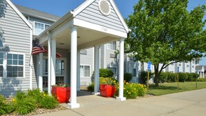 A building with a covered porch, a flag, and numbered address 1100.
