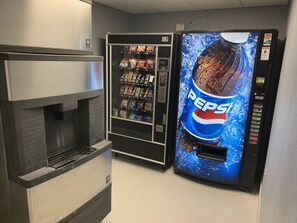 Máquina expendedora con el logotipo de Pepsi y un dispensador de bebidas.