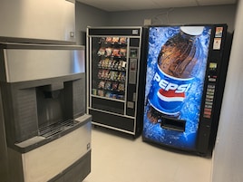 Máquina expendedora con el logotipo de Pepsi y un dispensador de bebidas.