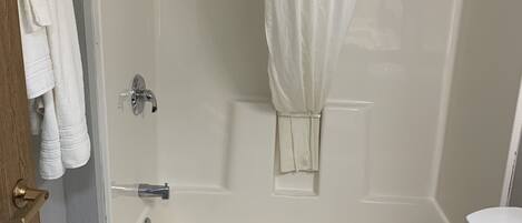 Un baño con ducha, inodoro y lavabo.