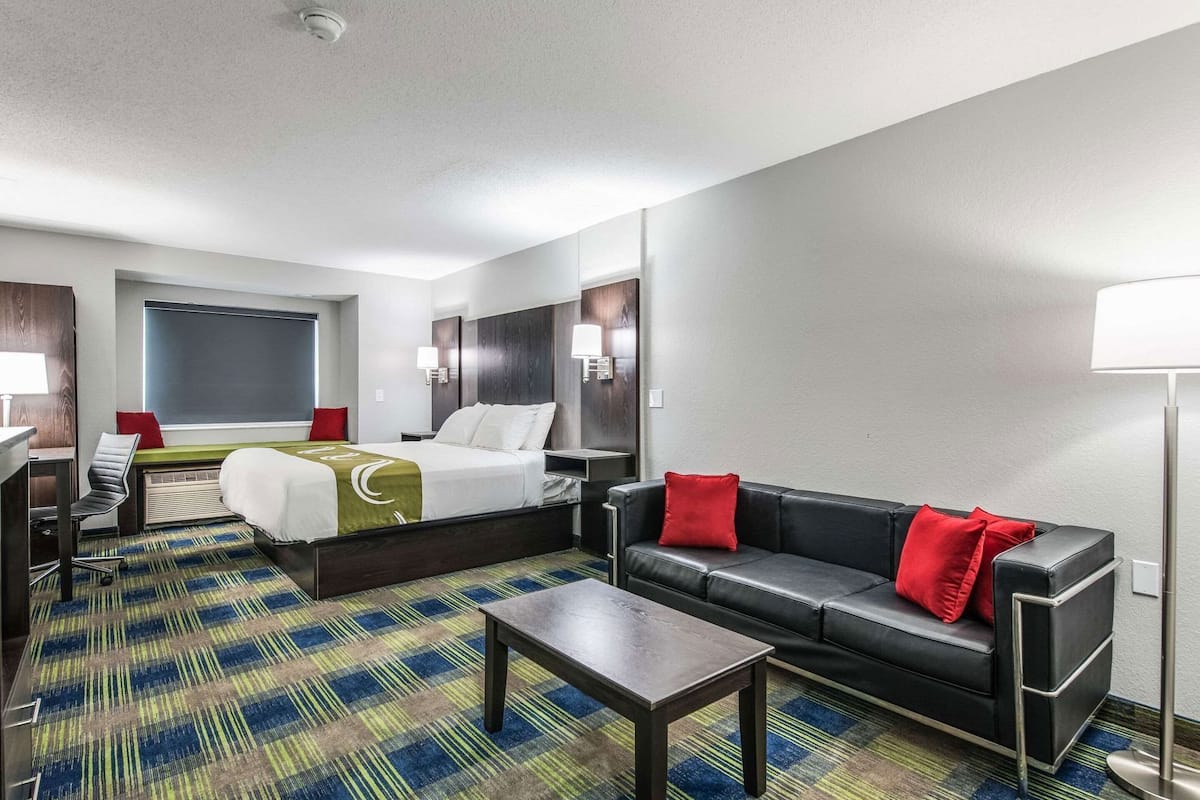 Ein Hotelzimmer mit Bett, Sofa, Schreibtisch und Stuhl.