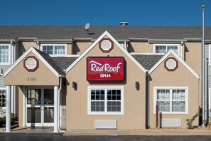 A Red Roof Inn with a prominent red sign, a number '3125' on the building, and a satellite dish on the roof.