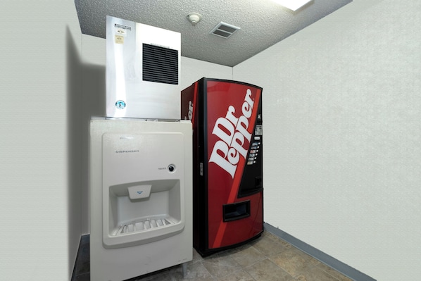 A vending machine and a small refrigerator in a corner.