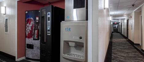 A hotel hallway with vending machines, including a Dr Pepper and an ice dispenser.
