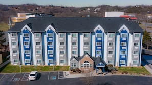 A multi-story hotel with a central entrance and parking lot. - Microtel Inn & Suites by Wyndham Pigeon Forge (Pigeon Forge)