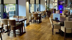 A spacious restaurant with high ceilings, large windows, and wooden flooring. - Copthorne Hotel Newcastle (Newcastle-upon-Tyne)