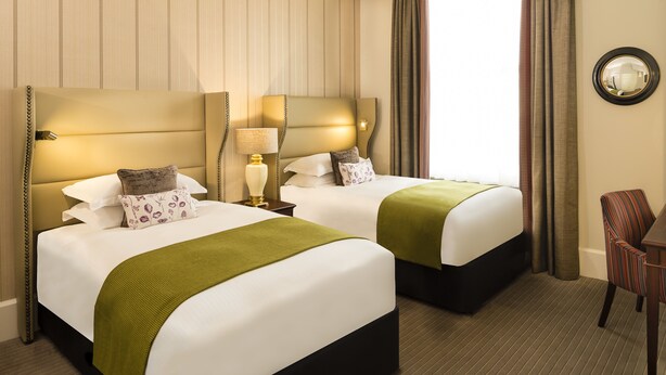 A hotel room with two beds, a mirror, a chair, and a lamp. - The Bailey's Hotel London Kensington (London)