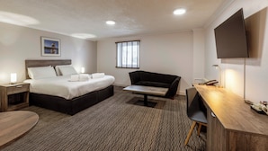 A modern hotel room with a bed, a desk, a chair, a TV, and a window with blinds. - Copthorne Hotel Aberdeen (Aberdeen)