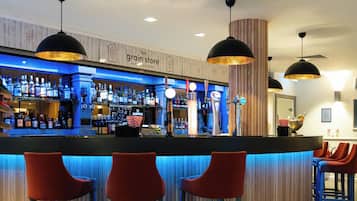 A bar area with a counter, stools, and a sign that reads 'The Grain Store.'