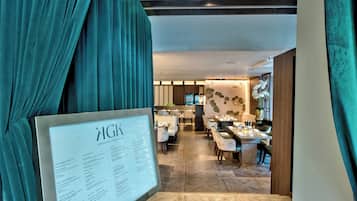 A restaurant with a menu board, wooden flooring, and a view of the dining area.