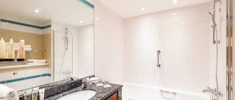 A modern bathroom with a double sink, a large mirror, and a walk-in shower.