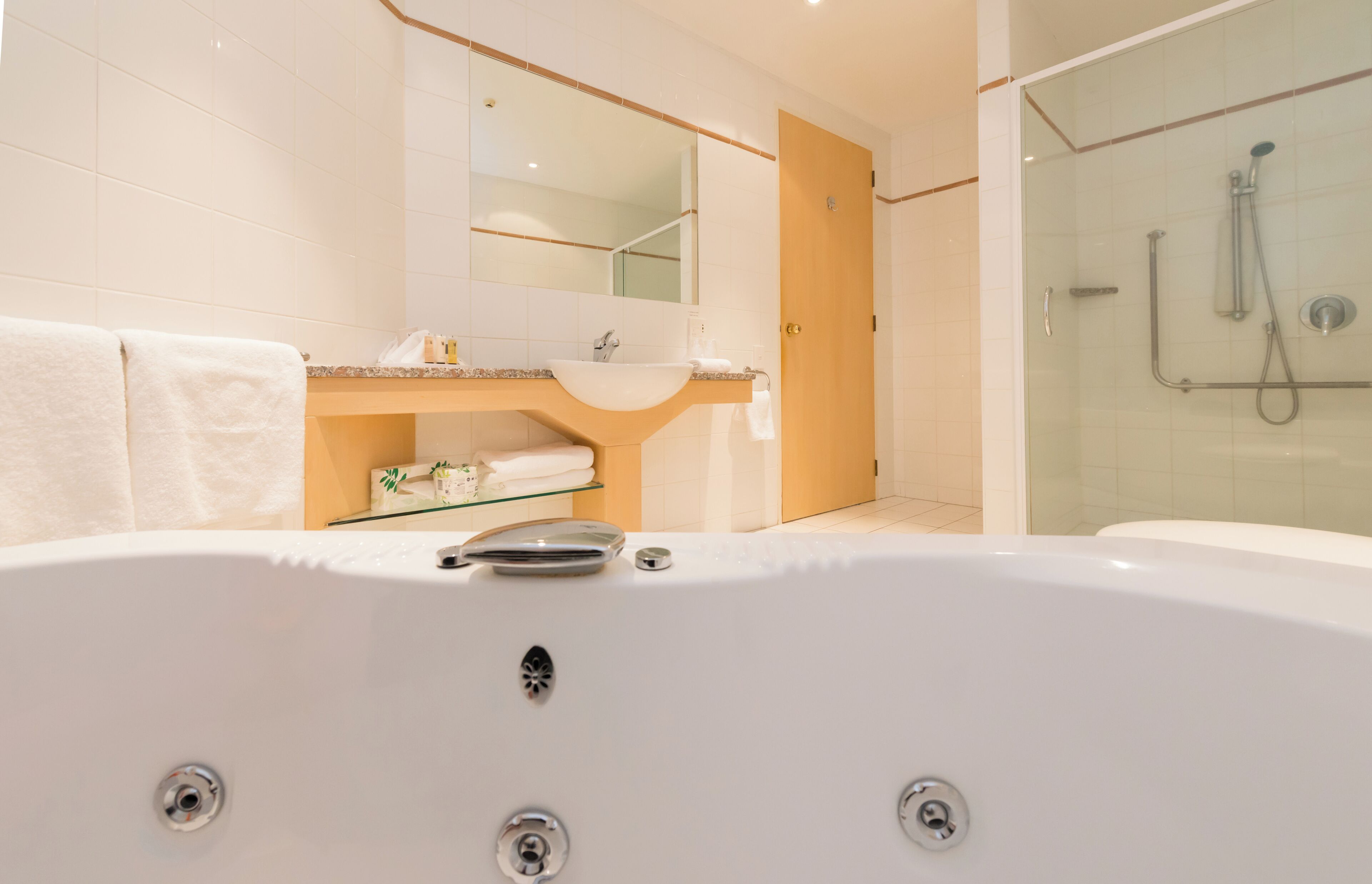 Un baño moderno con una bañera grande, una ducha con cerramiento de vidrio y un lavabo con espejo.