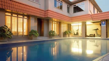 Una piscina al aire libre, una piscina climatizada, tumbonas