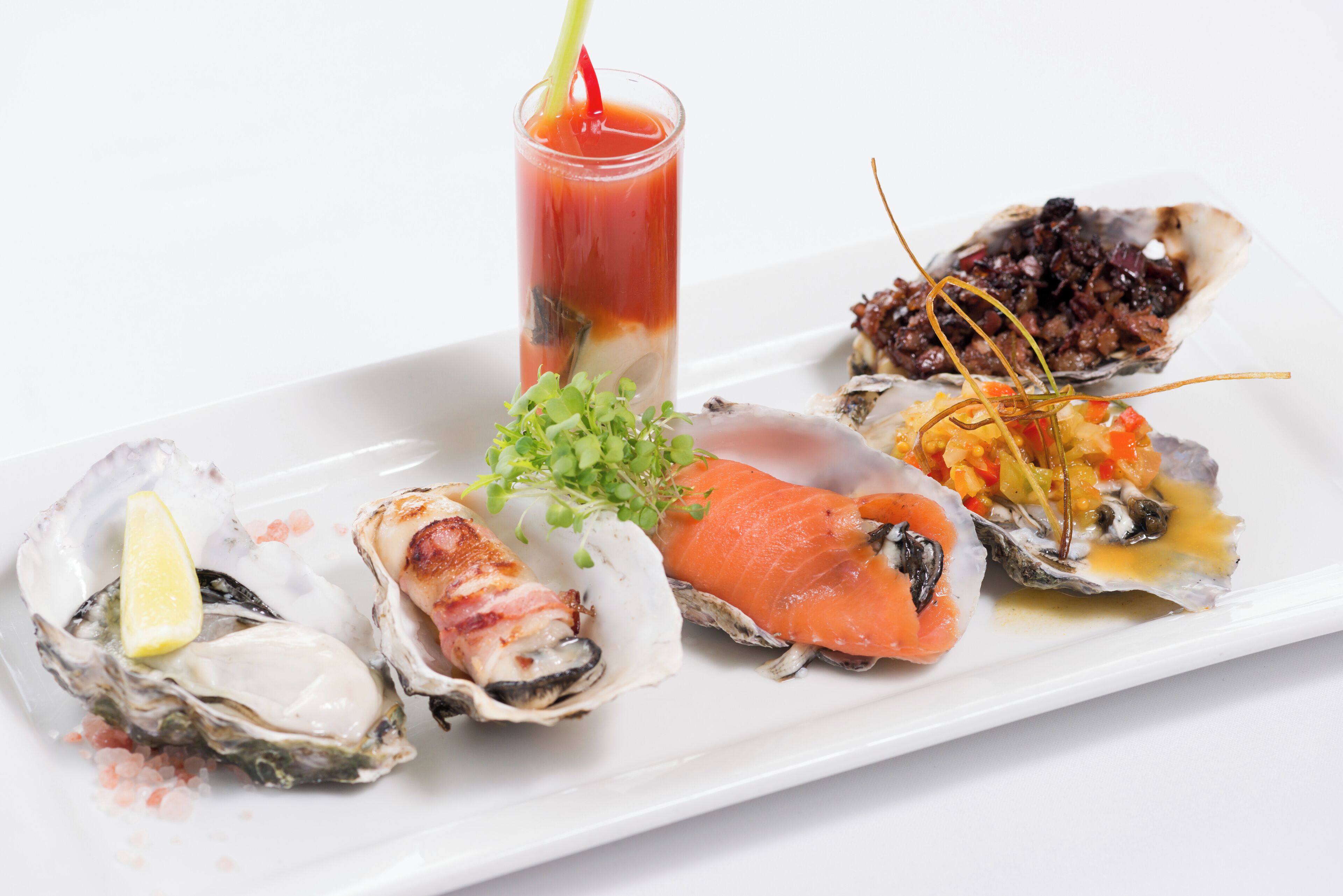 Diversos platos de mariscos, incluyendo ostras, salmón y un cóctel.